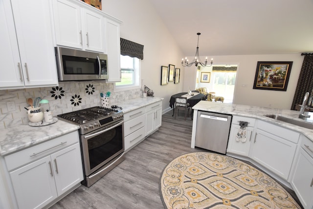 9466 Heritage, Goodrich, MI 48438 - kitchen featuring appliances with stainless steel finishes, a sink, a chandelier, tasteful backsplash, and white cabinetry