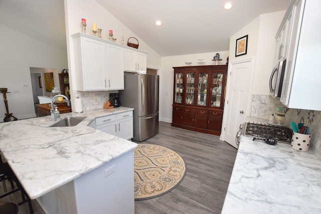 9466 Heritage, Goodrich, MI 48438 - kitchen with stainless steel appliances, lofted ceiling, a sink, a peninsula, and white cabinets