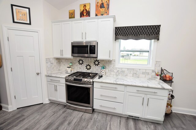 9466 Heritage, Goodrich, MI 48438 - kitchen with appliances with stainless steel finishes, wood finished floors, backsplash, and vaulted ceiling