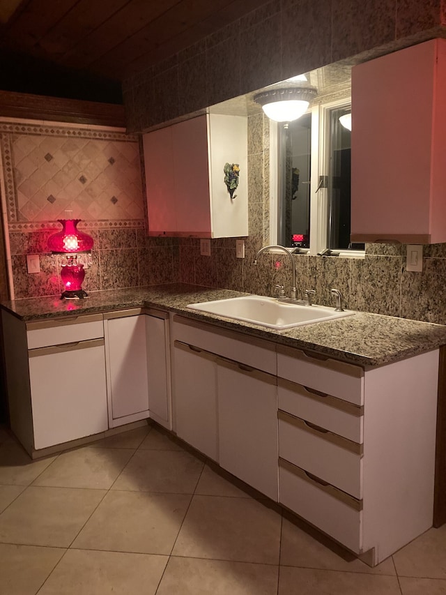 1548 Sunterra Trl, Boyne City, MI 49712 - kitchen featuring a sink, white cabinetry, decorative backsplash, and light tile patterned floors