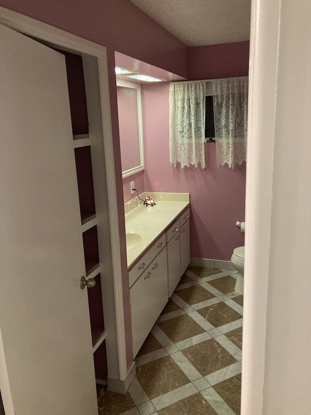 1548 Sunterra Trl, Boyne City, MI 49712 - bathroom with double vanity, toilet, baseboards, and inlaid floor details