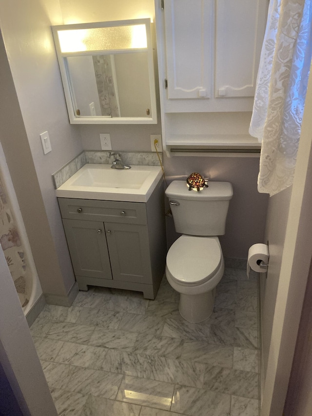 1548 Sunterra Trl, Boyne City, MI 49712 - full bathroom featuring toilet, vanity, baseboards, and marble look tiles