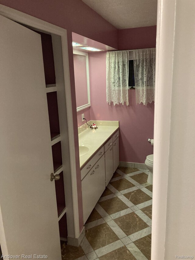 1548 Sunterra Trl, Boyne City, MI 49712 - bathroom with double vanity, toilet, baseboards, and inlaid floor details
