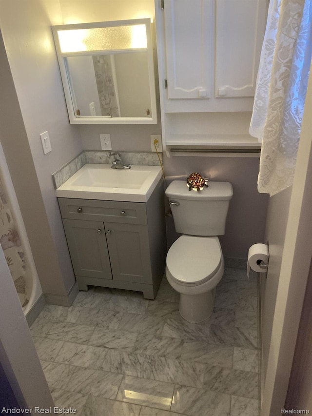 1548 Sunterra Trl, Boyne City, MI 49712 - full bath featuring toilet, vanity, marble finish floors, and baseboards
