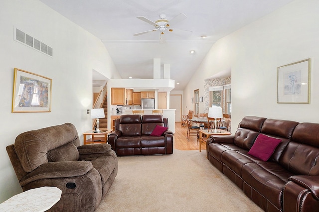 9098 Luea Ln, Swartz Creek, MI 48473 - living area featuring a ceiling fan, vaulted ceiling, light colored carpet, and stairs