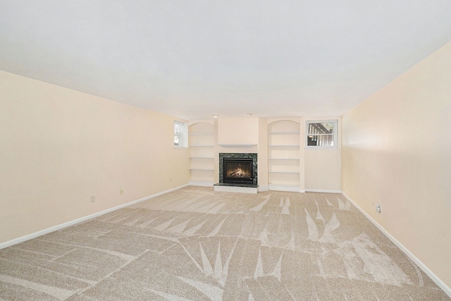 9098 Luea Ln, Swartz Creek, MI 48473 - unfurnished living room with baseboards, light colored carpet, a fireplace, and built in shelves