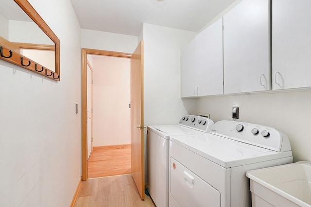 9098 Luea Ln, Swartz Creek, MI 48473 - washroom with washer and dryer, cabinet space, and light wood finished floors