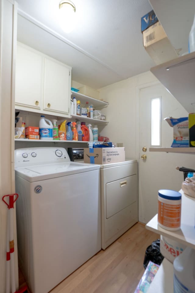 14424 Grenwich Ct, Shelby Twp, MI 48315 - clothes washing area with washer and dryer, cabinet space, and light wood-style floors