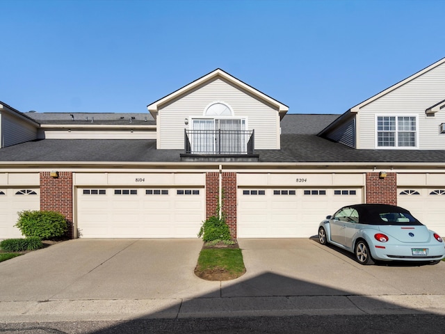 townhome / multi-family property with brick siding and driveway