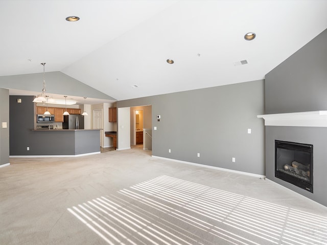 unfurnished living room featuring light colored carpet, vaulted ceiling, a glass covered fireplace, baseboards, and recessed lighting