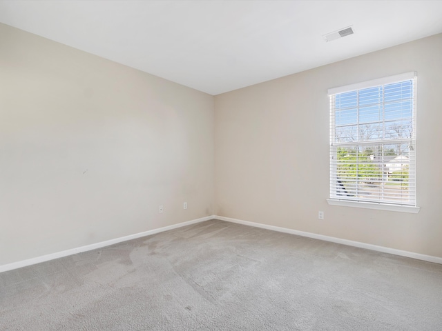 empty room with baseboards and light colored carpet