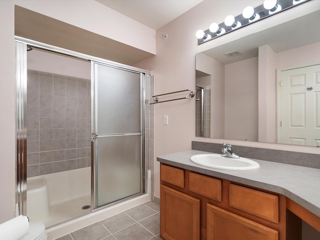 full bath with tile patterned flooring, a shower with door, vanity, and toilet