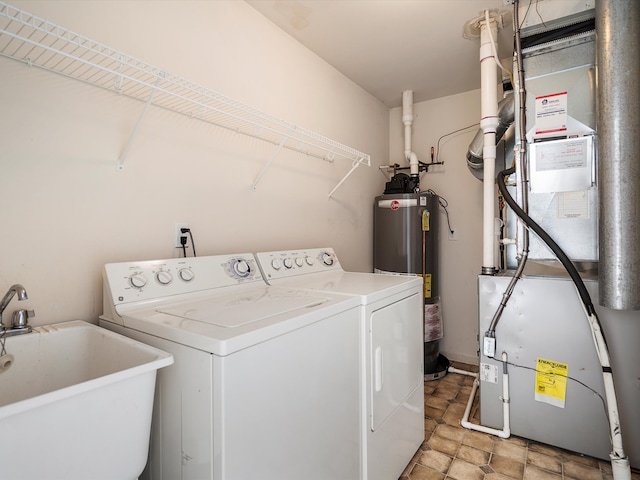 clothes washing area with washer and clothes dryer, gas water heater, and heating unit