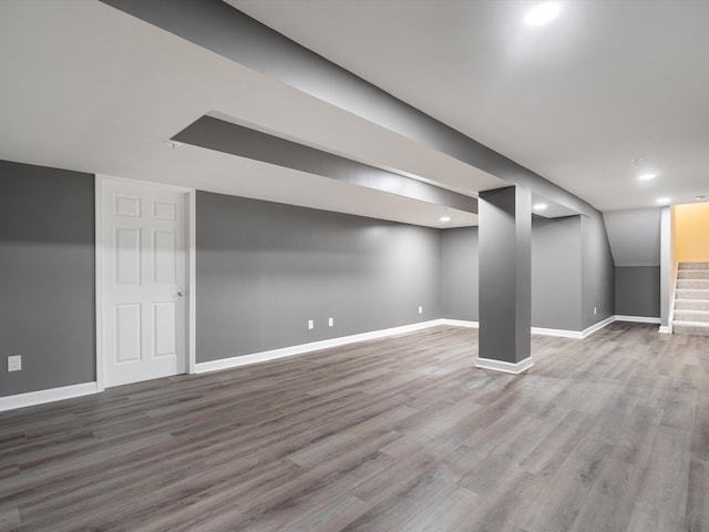finished below grade area with stairs, baseboards, wood finished floors, and recessed lighting