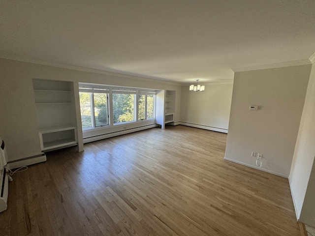 unfurnished room featuring crown molding, a chandelier, wood finished floors, and a baseboard heating unit