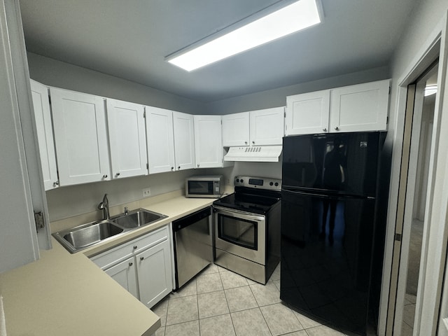 kitchen featuring stainless steel appliances, under cabinet range hood, a sink, and white cabinets