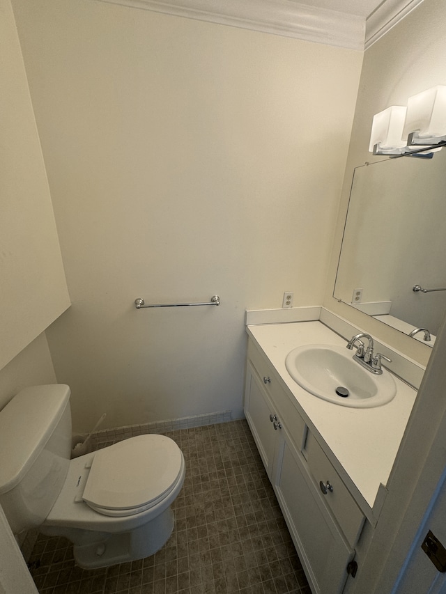 half bath featuring toilet, crown molding, and vanity