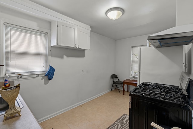 17041 Henry St, Melvindale, MI 48122 - kitchen with freestanding refrigerator, stainless steel gas stove, white cabinets, baseboards, and wall chimney exhaust hood
