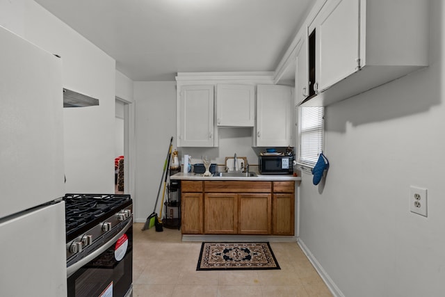 17041 Henry St, Melvindale, MI 48122 - kitchen featuring freestanding refrigerator, gas range, light countertops, baseboards, and brown cabinetry
