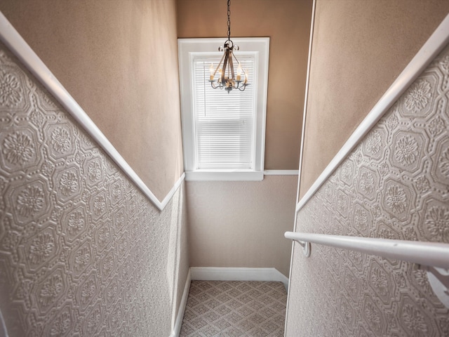 stairs with a chandelier and baseboards