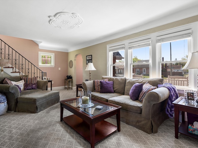 carpeted living room featuring stairway and baseboards