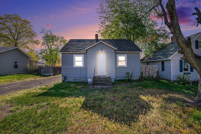 bungalow featuring entry steps, a chimney, and an outbuilding
