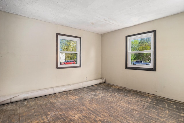 empty room featuring healthy amount of natural light and wood finished floors