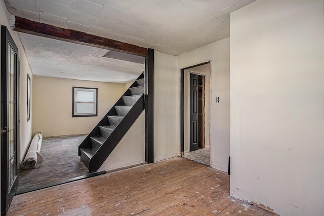 basement featuring hardwood / wood-style flooring and stairs
