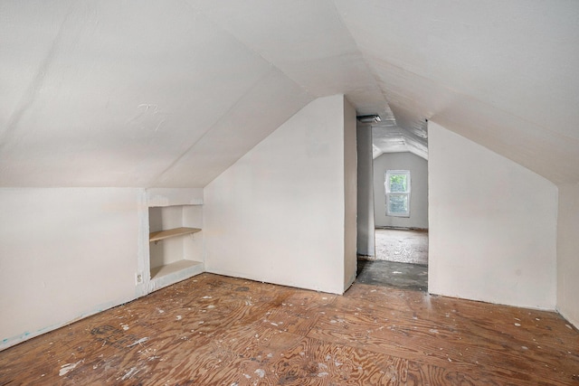 additional living space with built in shelves and vaulted ceiling