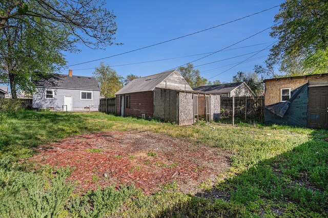 view of yard featuring a storage shed, fence, and an outbuilding