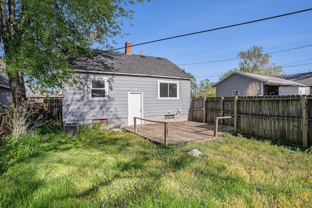 back of property featuring a wooden deck, a chimney, roof with shingles, and central AC
