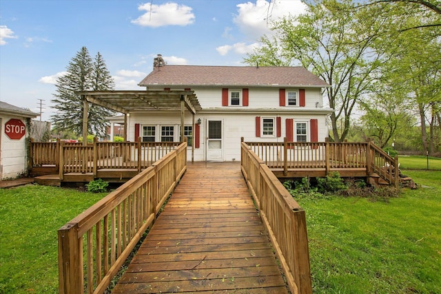 back of house featuring a pergola, a lawn, a deck, and a chimney