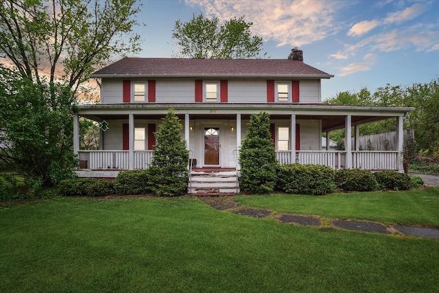 farmhouse-style home with a chimney, a porch, and a front yard