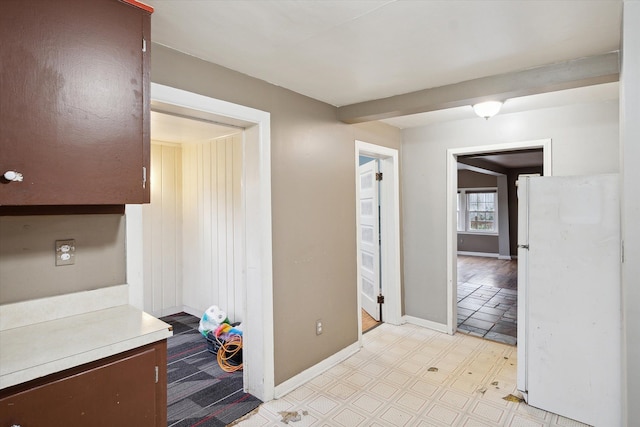 corridor with light floors and baseboards