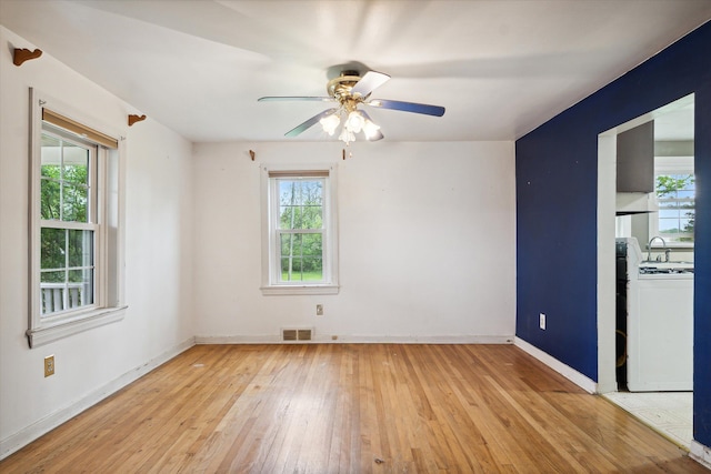 unfurnished room with healthy amount of natural light, light wood-style flooring, baseboards, and ceiling fan