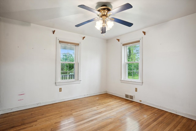 spare room with light wood finished floors, ceiling fan, and baseboards
