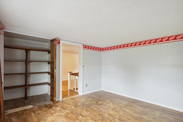 unfurnished bedroom with wood finished floors and baseboards