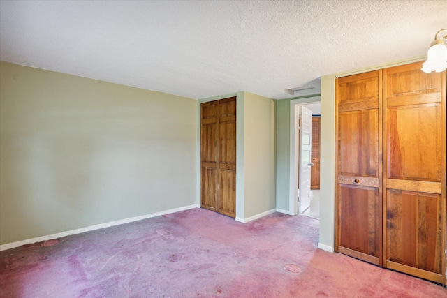 unfurnished bedroom with carpet, baseboards, and a textured ceiling