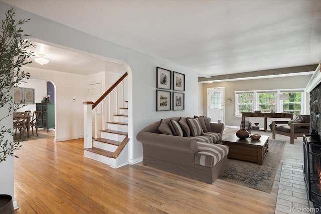 260 S Dexter St, Pinckney, MI 48169 - living area featuring arched walkways, light wood-type flooring, stairway, and baseboards