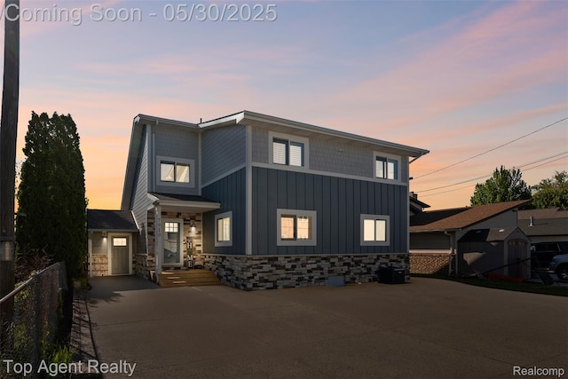 7910 Anchor Bay Dr, Clay, MI 48001 - modern home featuring board and batten siding, stone siding, and central AC unit