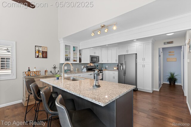 7910 Anchor Bay Dr, Clay, MI 48001 - kitchen featuring appliances with stainless steel finishes, a sink, white cabinets, a kitchen bar, and glass insert cabinets