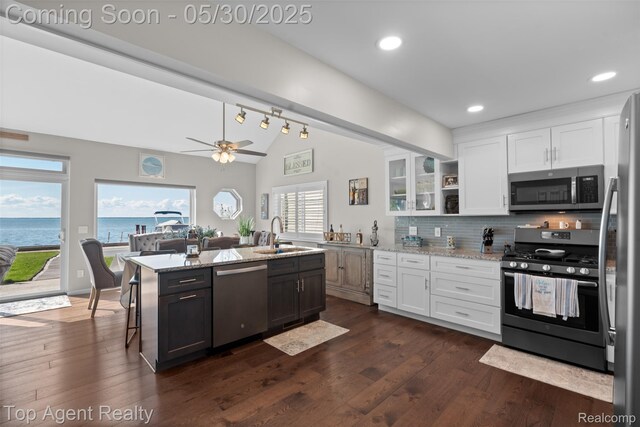 7910 Anchor Bay Dr, Clay, MI 48001 - kitchen featuring stainless steel appliances, a sink, lofted ceiling, white cabinetry, and light stone countertops