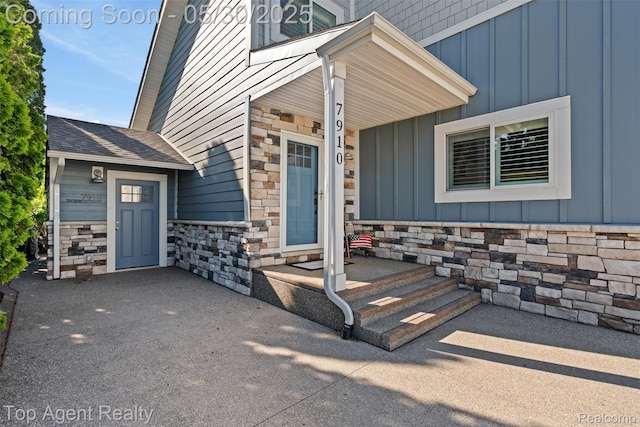 7910 Anchor Bay Dr, Clay, MI 48001 - property entrance featuring board and batten siding, stone siding, and a shingled roof