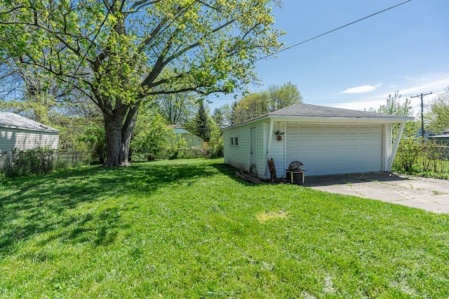 view of yard featuring a detached garage and an outbuilding
