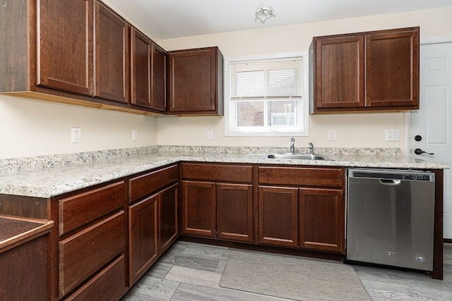kitchen with stainless steel dishwasher, a sink, light countertops, and dark brown cabinets