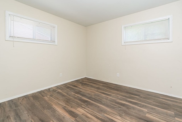 spare room featuring dark wood finished floors and baseboards
