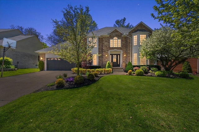 georgian-style home with a garage, driveway, a front lawn, and brick siding