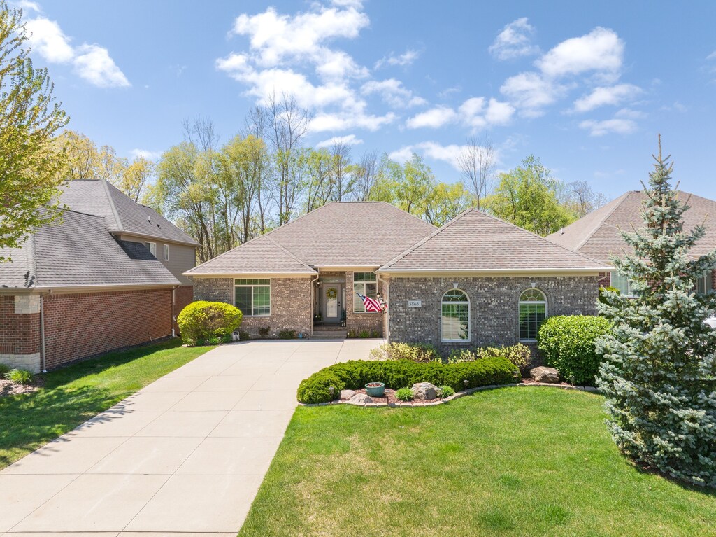 58651 Glacier Club Dr, Washington, MI 48094 - view of front of property with brick siding, driveway, a front lawn, and a shingled roof