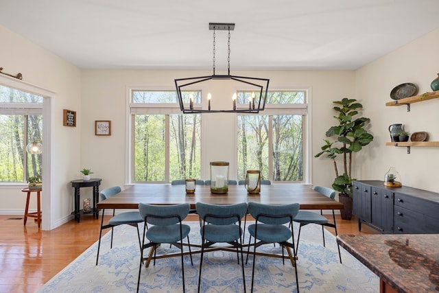 58651 Glacier Club Dr, Washington, MI 48094 - dining room with healthy amount of natural light, light wood finished floors, a chandelier, and baseboards