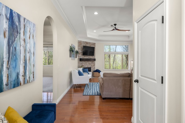 58651 Glacier Club Dr, Washington, MI 48094 - living area with a ceiling fan, wood finished floors, ornamental molding, arched walkways, and a fireplace